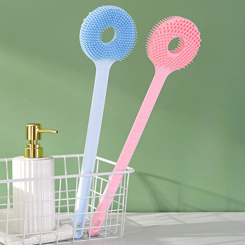 Cepillo de baño 2 en 1 con diseño ergonómico y mango largo, cerdas suaves para exfoliar y masajear, en tonos pastel rosa y azul.
