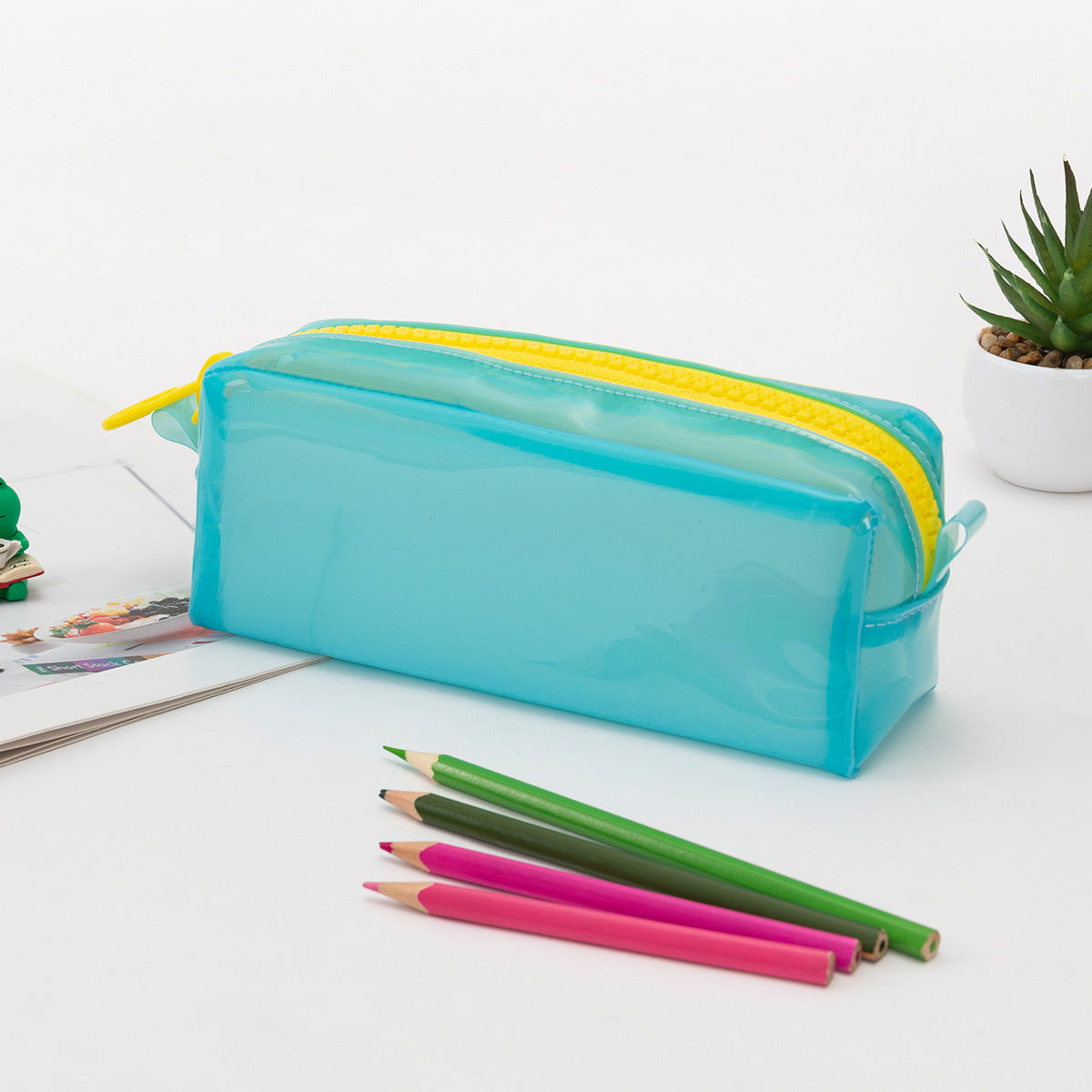 Estuche azul de silicona transparente con cremallera amarilla, ideal para almacenar artículos de papelería con gran capacidad.