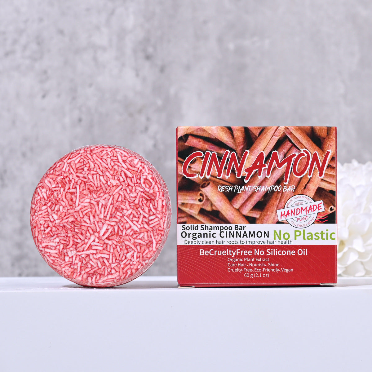 Barra de jabón de canela para cabello saludable, hecha a mano, presentada junto a su empaque con diseño natural y libre de plástico.