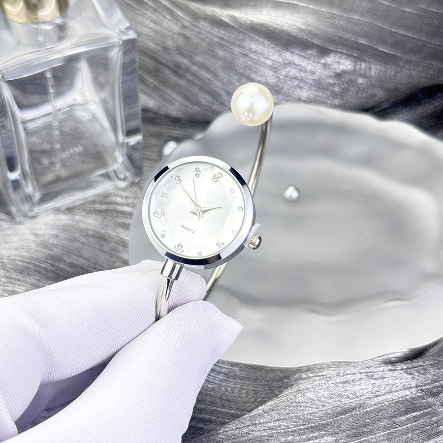 Detalle del reloj con perla en la correa