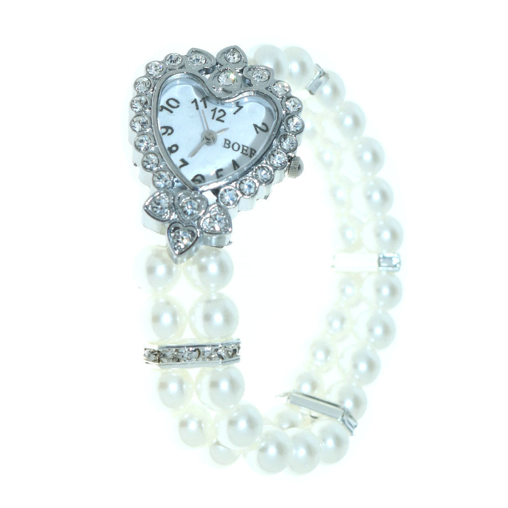 Detalle del reloj de cuarzo con pulsera elástica y corazón metálico