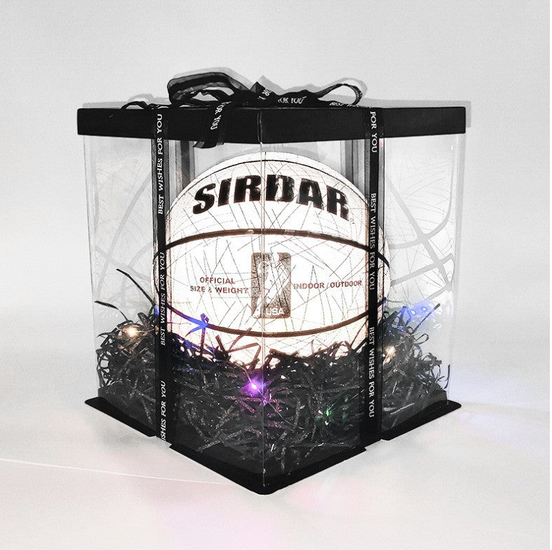 Balón de baloncesto fluorescente SIRDAR en caja de presentación con iluminación decorativa, ideal como regalo deportivo.