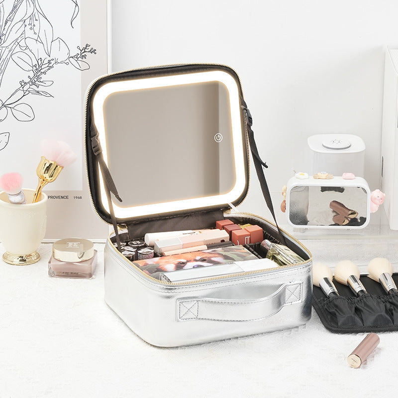 Neceser de maquillaje plateado con espejo LED y divisores ajustables. Ideal para organizar productos de belleza en viajes.