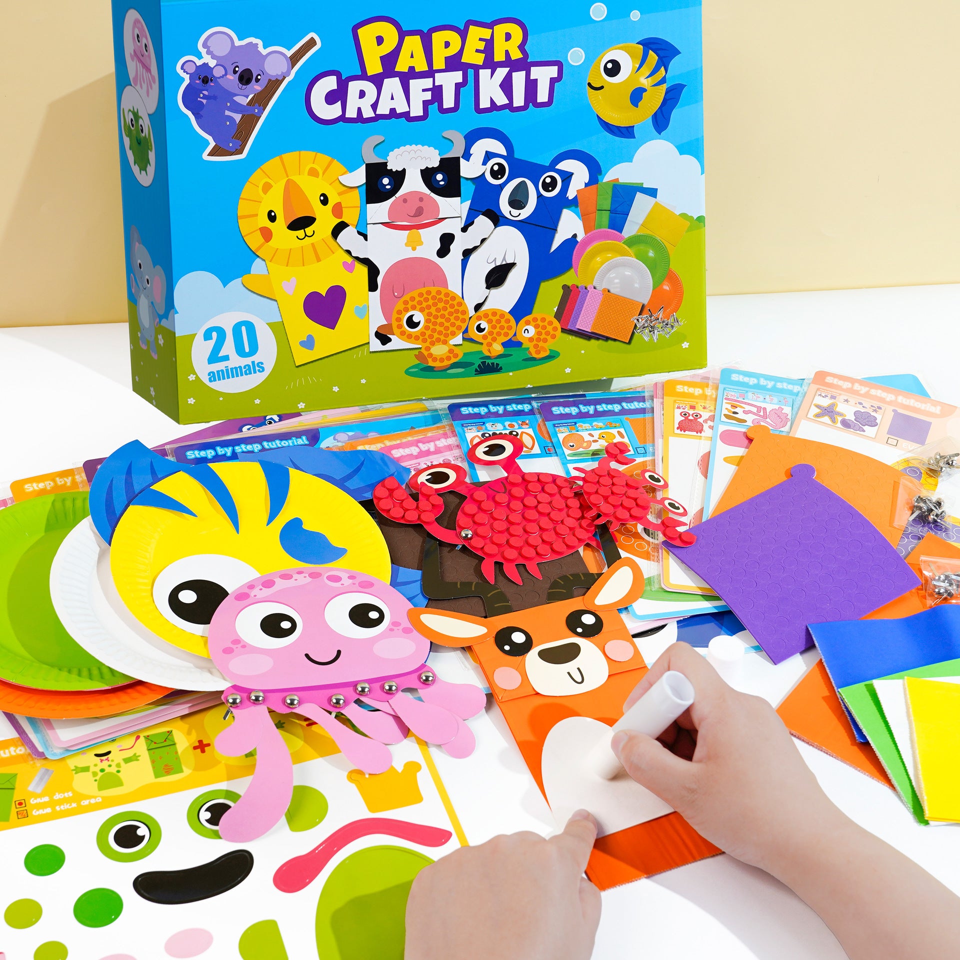 Niños creando animales de papel con el Kit de Manualidades para Niños: Animales de Papel, Disfraces y Más, incluye plantillas, pegamento y figuras.