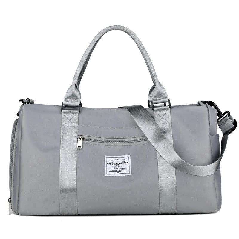 Bolsa deportiva impermeable gris con asas dobles y correa larga. Ideal para gimnasio, viajes cortos y uso diario.