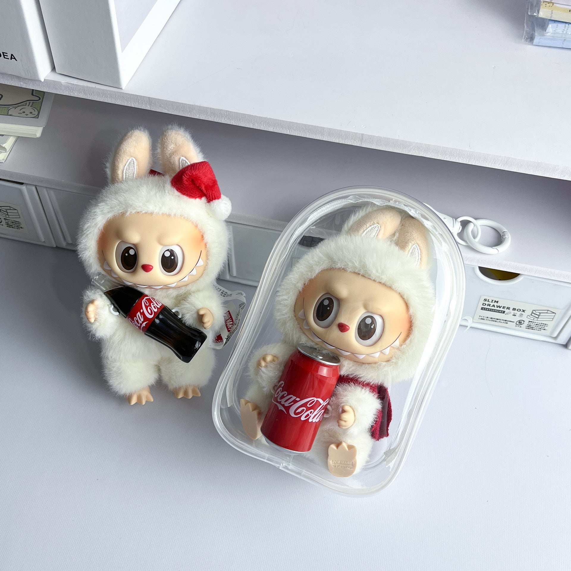 Bolsa protectora transparente para figuras Labubu de 15 cm con diseño navideño y lata de Coca-Cola, perfecta para mantenerlas limpias.