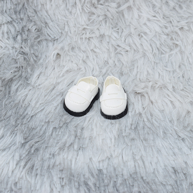 Zapatos tipo mocasín blancos sobre alfombra gris para muñecos Labubu de 17CM, ideales para juegos de vestir y colección.