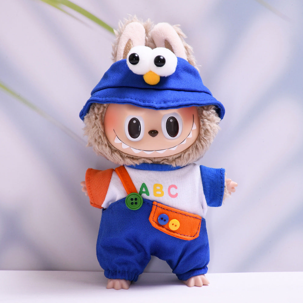 Muñeco tipo Labubu con conjunto azul y gorro con ojos grandes. Ropa inspirada en personajes infantiles, sin incluir el muñeco.