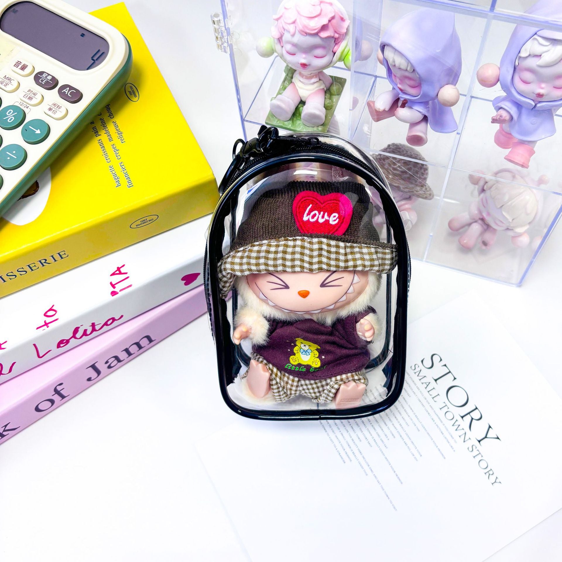 Bolsa protectora transparente para figura Labubu Have a Seat de 15 cm con diseño de gorro y ropa de cuadros, ideal para coleccionistas.