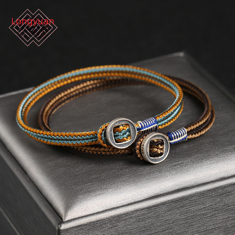 Pulsera tejida con hilo negro y botón redondo de plata 925 al centro.