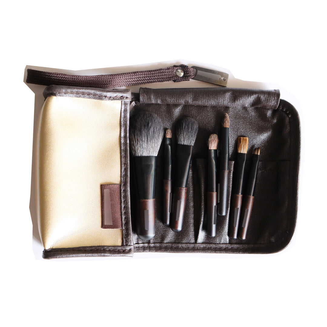 Set de 7 brochas de maquillaje con estuche dorado y marrón, incluye pinceles de animales, sombra y ébano para rostro y ojos.