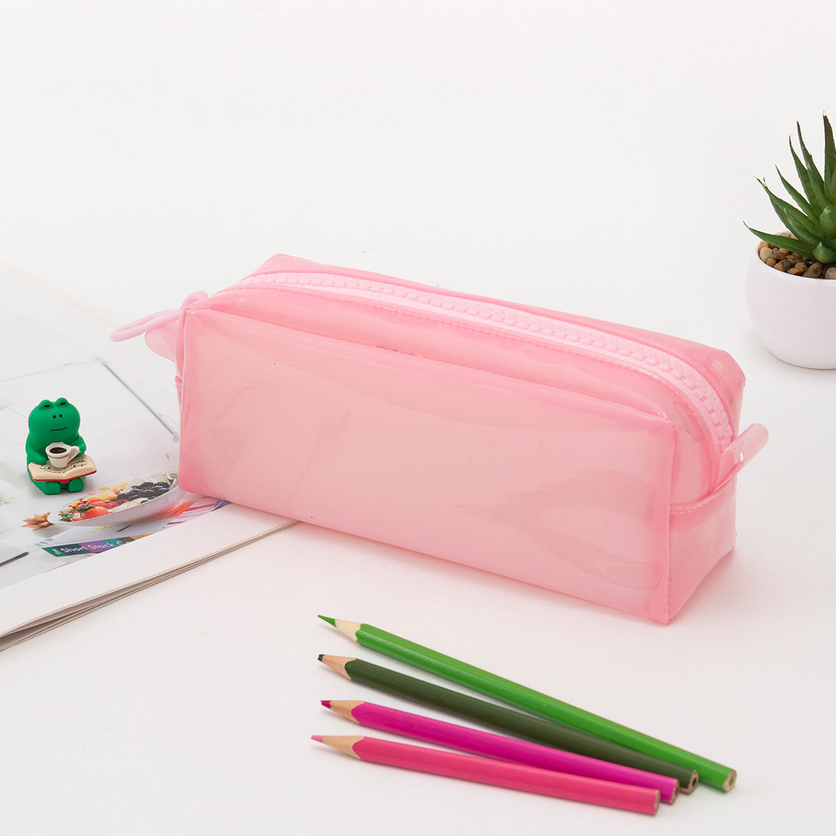 Estuche rosa de silicona transparente con cremallera, perfecto para guardar lápices y bolígrafos con estilo y funcionalidad.