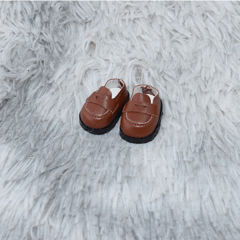 Zapatos tipo mocasín marrones sobre alfombra gris para muñecos Labubu de 17CM, parte de la colección de calzado para muñecos.