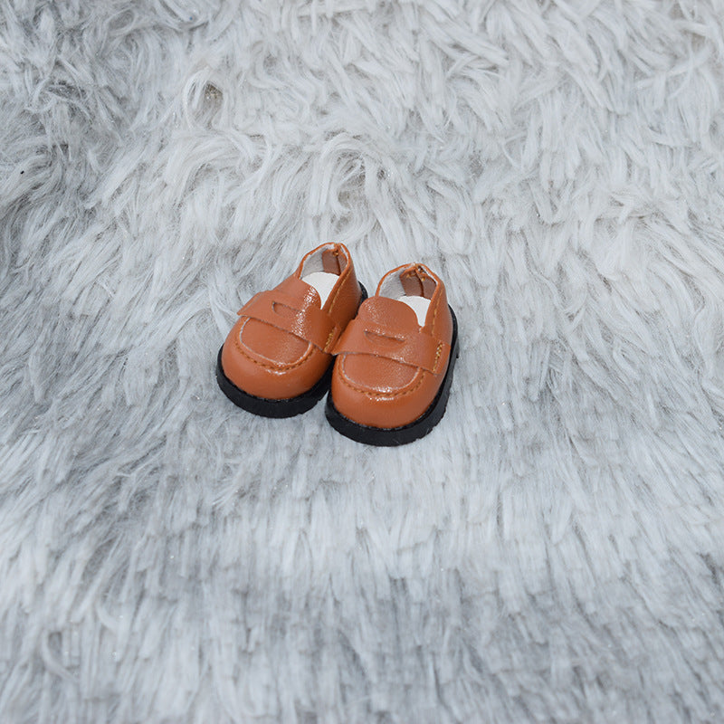 Zapatos tipo mocasín color camel sobre alfombra gris para muñecos Labubu de 17CM, ideales para personalizar figuras de juguete.